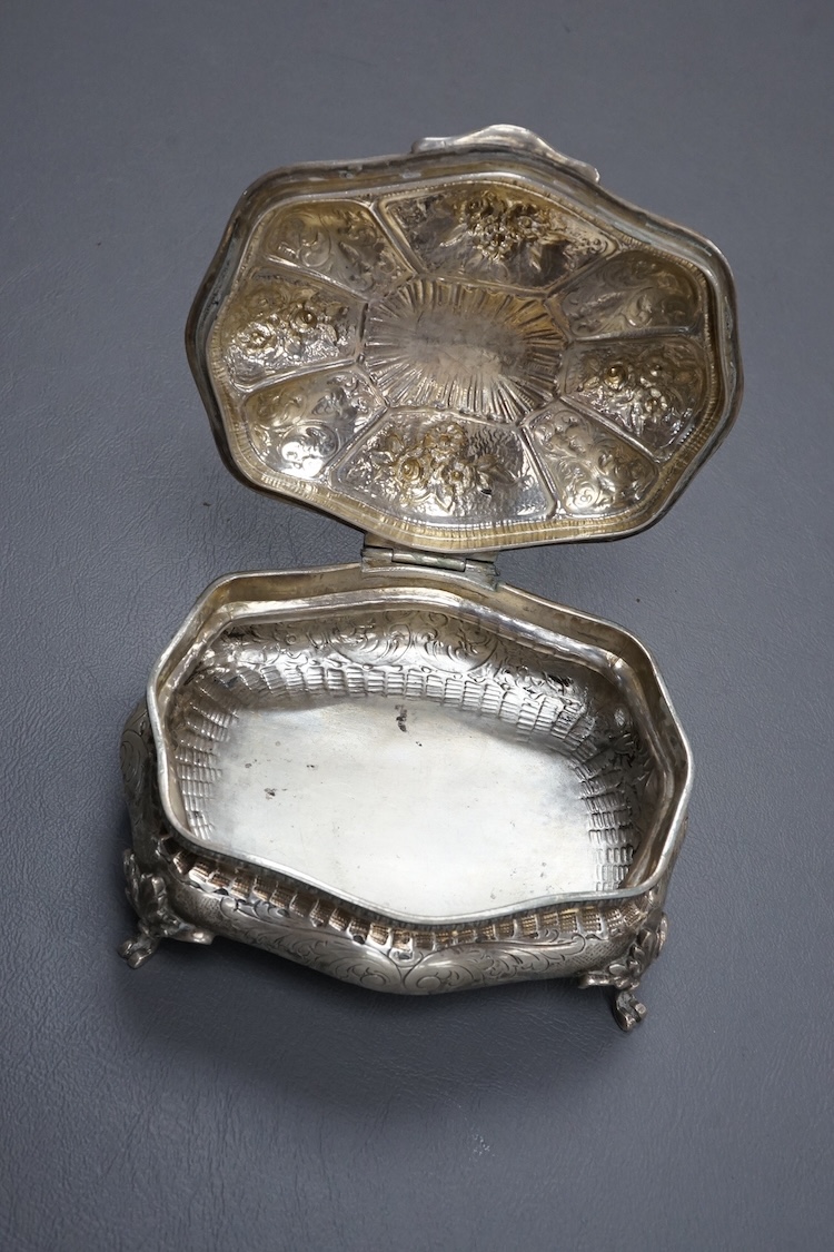An ornate early 20th century Italian 800 standard white metal trinket casket, of shaped oval form, with embossed and engraved decoration, on four cabriole feet, 12.2cm, 9.2oz.